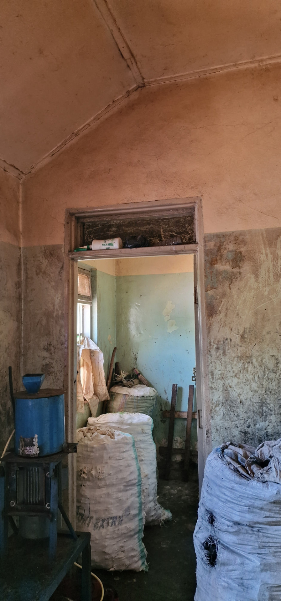 Inner room with vaulted plaster ceiling looking through a doorway into a store room
