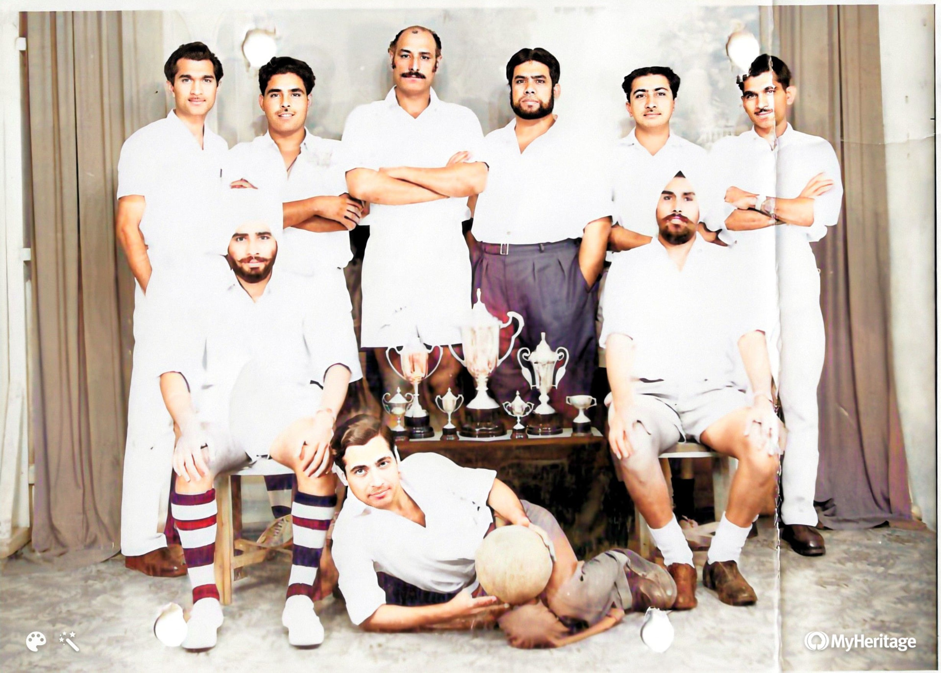 Sports team group photograph with trophies, colourised