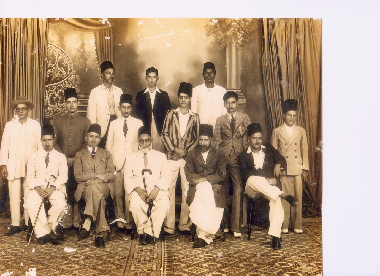 Large sepia family and community group portrait in a studio