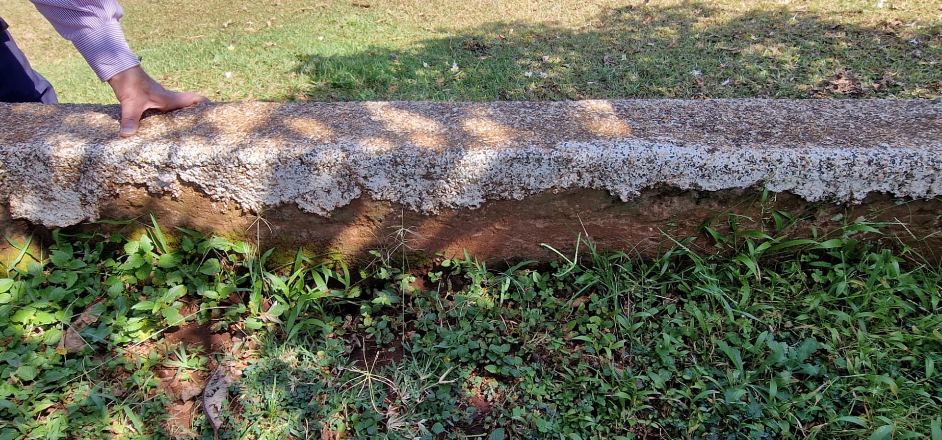 A hand resting on the weathered stone edge of the tomb