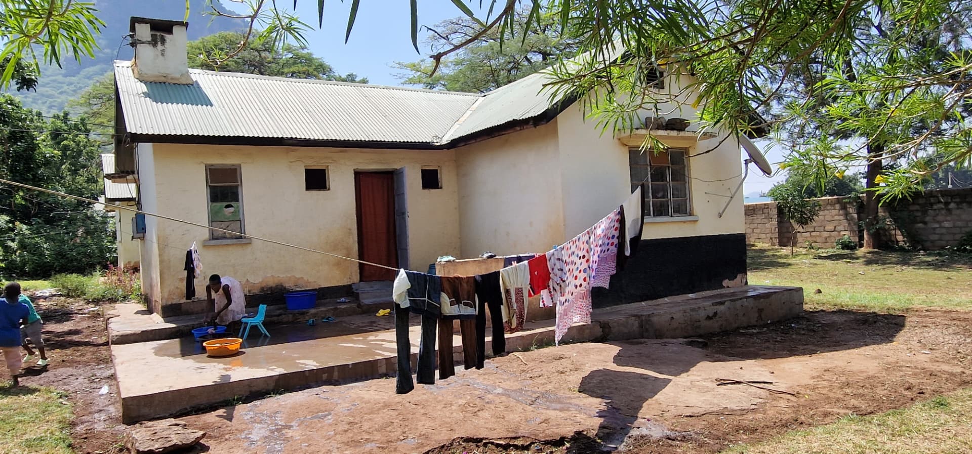 Courtyard with laundry drying on lines and washing being done in basins