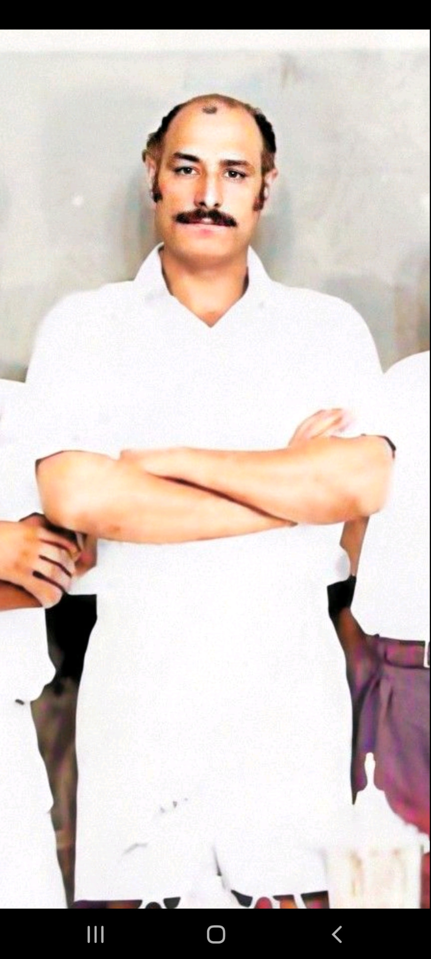 Dada Abu standing with arms crossed in whites